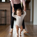 First steps of little girl at home interior